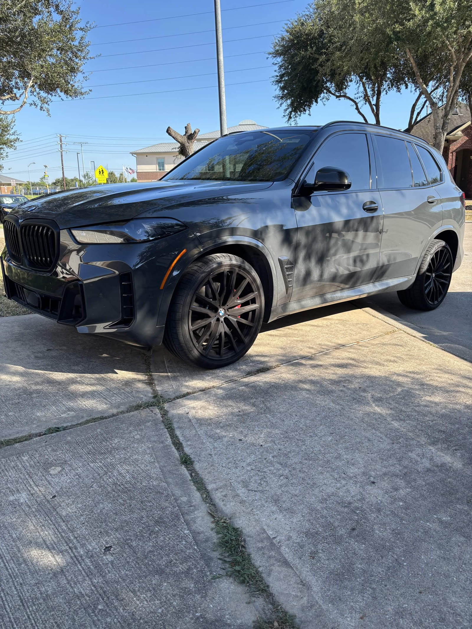Dark grey BMW X5 with black wheels and red calipers after detailing