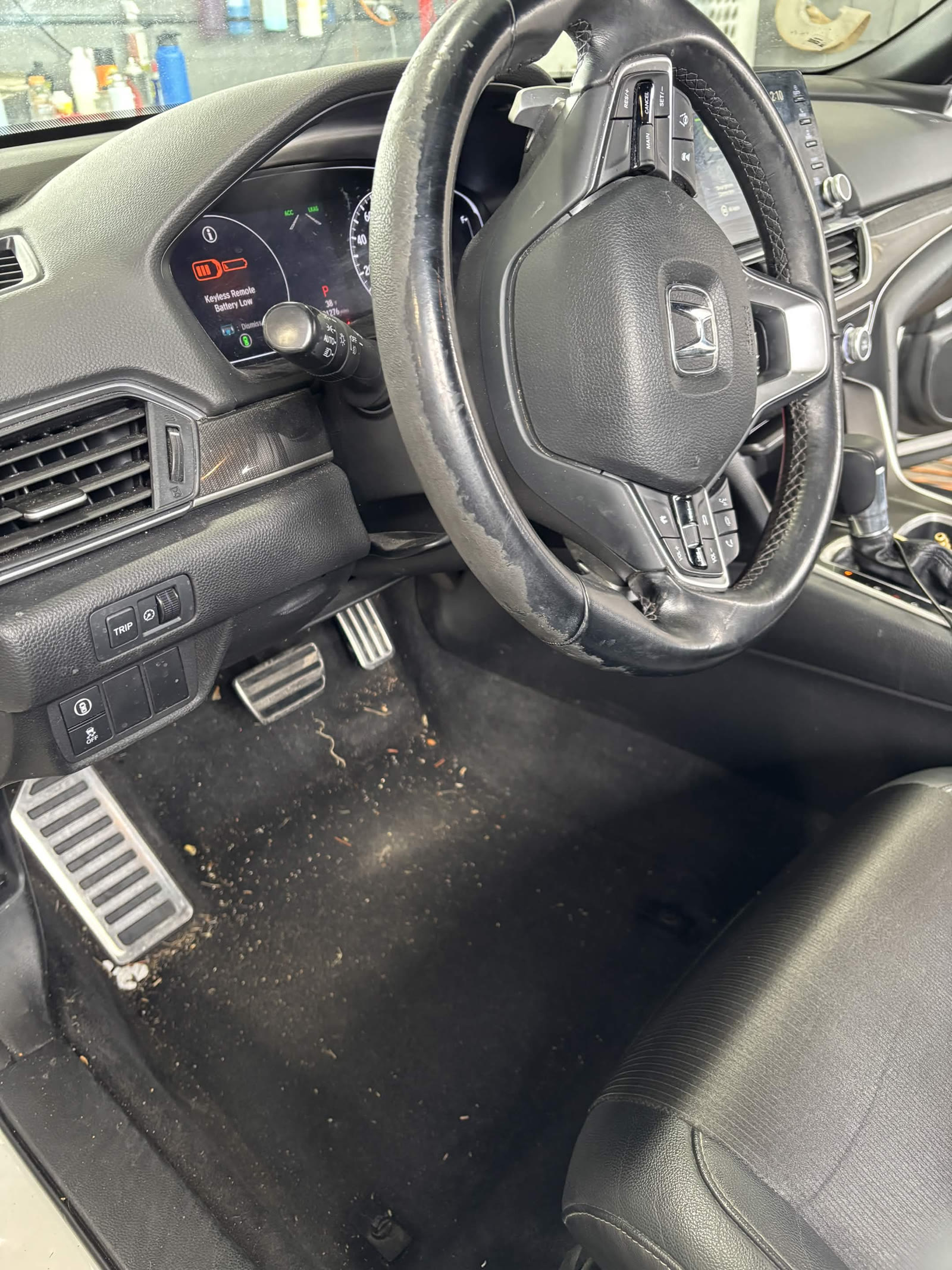 Honda driver footwell and worn steering wheel before interior detail